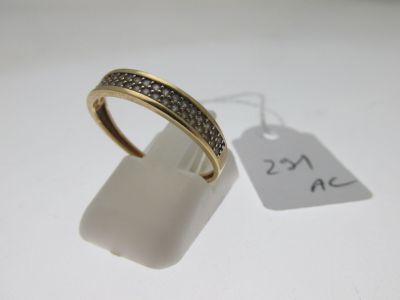 gros plan d'une bague sur une surface blanche avec une étiquette de prix