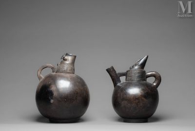 pair of bronze vases with handles and handles on a gray background