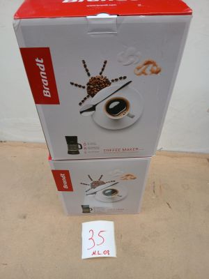 une boîte de café posée par terre à côté d'une autre boîte de café