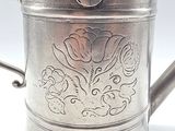 a silver cup with a flower design on it