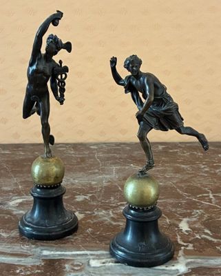 deux statues représentant un homme et une femme, posées au sommet d'une boule