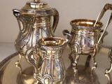 a silver tea set on a silver tray on a table