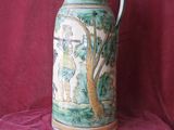 a vase with a painting on it on a red cloth
