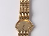an image of a close up of a gold watch on a white surface