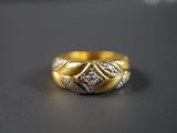 une photo d'une bague en or sertie de diamants posée sur une table