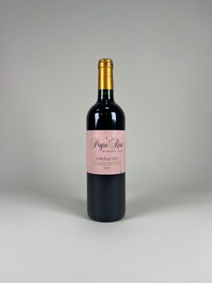 a bottle of red wine sitting on top of a white table