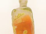 a glass bottle with an orange and green design on it