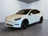 une Tesla Model Y blanche garée dans une pièce blanche