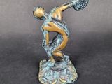 statue of a man holding a tennis racquet on top of a table