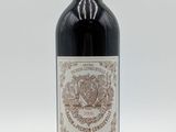 une bouteille de vin rouge posée sur une table blanche