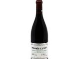 the bottle of red wine is sitting on a white surface