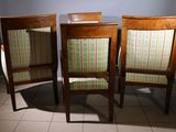 three wooden chairs sitting next to each other on a tiled floor