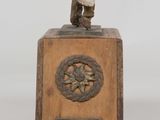 statue of a man holding a baseball bat on top of a wooden plaque