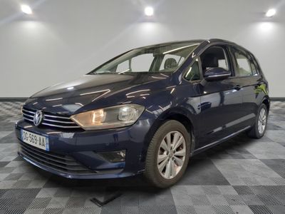 une Volkswagen Golf bleue garée sur un sol à damier dans un garage