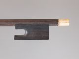 gros plan d'un archet de violon avec un morceau de bois qui en sort