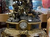 une horloge posée sur une table sur laquelle se trouve une statue