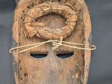 an image of a wooden mask with a rope around it ' s neck
