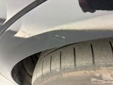 a close up of a car tire with a person ' s hand on it