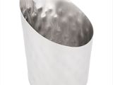 a silver cup that is sitting on a white surface