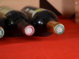 several bottles of wine are lined up on a red table