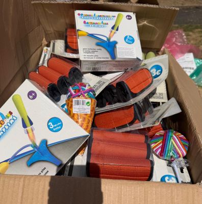 une boîte en carton remplie de fournitures scolaires et une paire de ciseaux