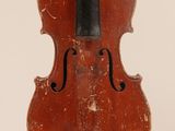 an old violin sitting on top of a white surface