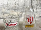 a glass bottle and a glass cup sitting on a table