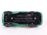a green toy car with black wheels on a white surface