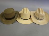 three hats are lined up on a table with a white background
