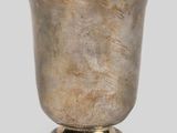 an antique silver cup on a pedestal on a gray background