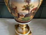a large vase with a painting on it on a table