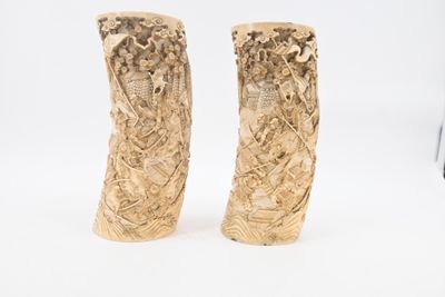 pair of carved elephant tusks on a white background