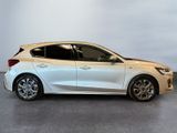 the white car is parked on the concrete floor in the room