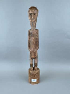 une statue en bois représentant un homme debout sur un socle
