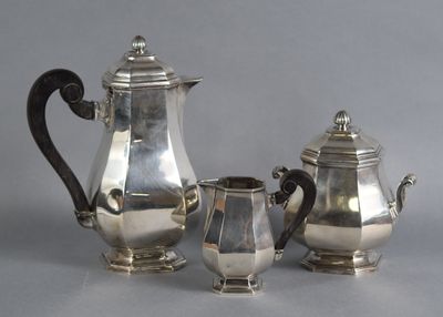 three pieces of silver tea and coffee set on a grey background