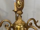 a gold candle holder with a candle on top of it