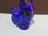 a blue glass figurine sitting on a white table