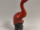 a red bird with a hat on top of it ' s head
