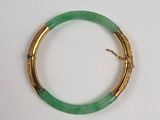 une image représentant un bracelet vert rehaussé de touches dorées sur un fond blanc