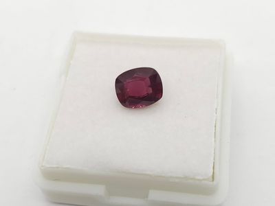 un gros plan d'un grenat rouge sur une surface blanche
