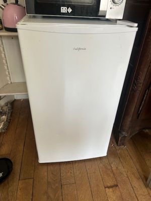 a microwave sitting on top of a refrigerator in a kitchen