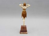 a statue of a woman standing on top of a wooden block