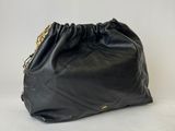 a black leather bag with a gold chain hanging from it