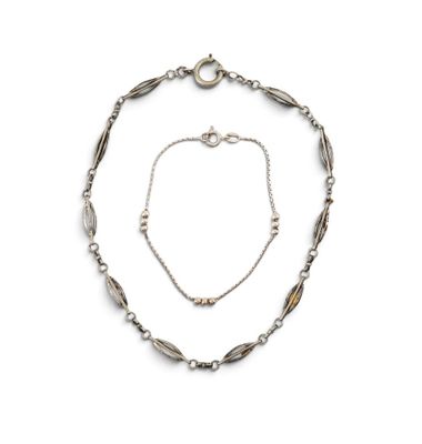 un gros plan d'un collier et d'un bracelet sur fond blanc