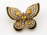 une photo d'une broche en forme de papillon jaune et noir, sertie de diamants