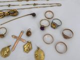 various gold and silver jewelry including rings, necklaces, rings, and a cross