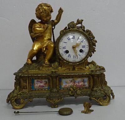a gold clock with an angel on top of it
