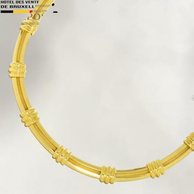 yellow gold plated bracelet with a round design on a white background