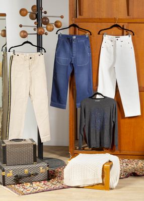 plusieurs paires de jeans suspendues à un portant dans une pièce
