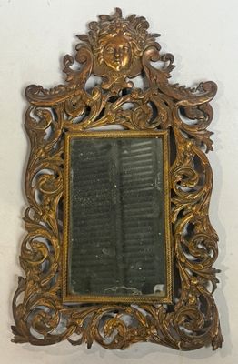 un miroir accroché au mur avec un cadre doré